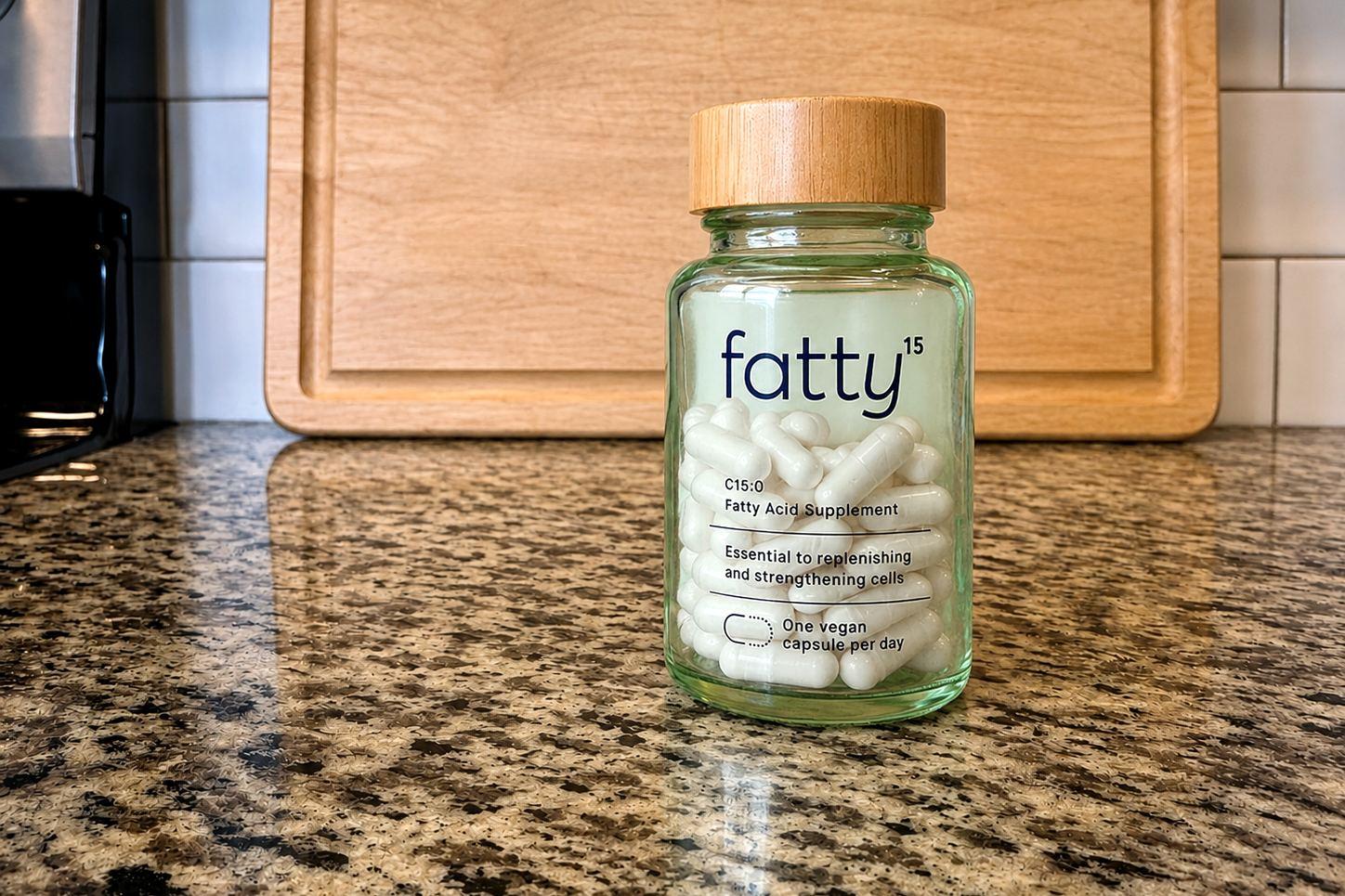 fatty15 C15:0 bottle with wooden cap on our kitchen counter, labeled Fatty Acid Supplement, one vegan capsule per day
