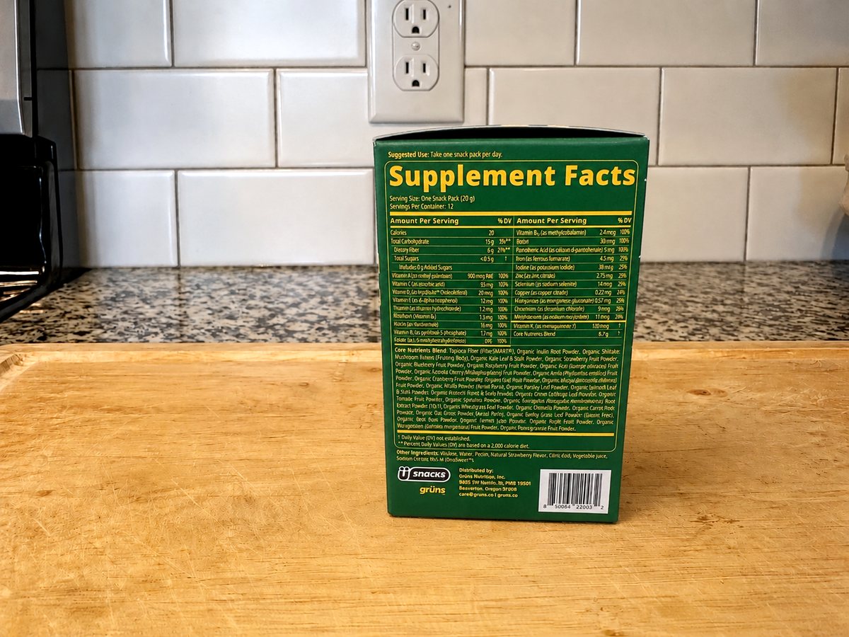 Grüns Superfoods Greens Gummies box Supplement Facts panel: serving one 20 g snack pack, 12 servings, quantified vitamins and minerals with daily values, and a 6.7 g proprietary Core Nutrients Blend with no per-ingredient amounts